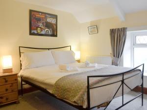 ein Schlafzimmer mit einem Bett mit zwei Handtüchern darauf in der Unterkunft Tirmynydd Farm Cottage in Dunvant
