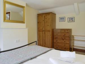 ein Schlafzimmer mit einem Bett, einer Kommode und einem Spiegel in der Unterkunft Tirmynydd Farm Cottage in Dunvant + 17 Fotos