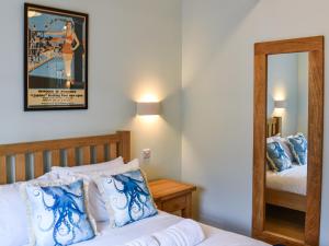 a hotel room with a bed and a mirror at Lower Stables in Newlyn