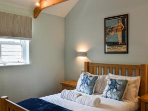 a bedroom with a bed with a poster on the wall at Lower Stables in Newlyn +17 photos