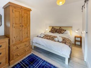 a bedroom with a bed and a wooden dresser at Hillview Cottage in Aberfeldy +10 photos
