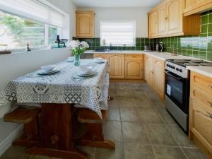 una cucina con un tavolo con un vaso di fiori sopra di Lawns Cottage a Helmsley