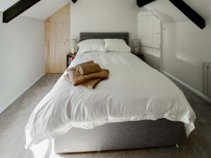 una camera da letto con un letto bianco con un asciugamano sopra di Lawns Cottage a Helmsley Altre 7 foto