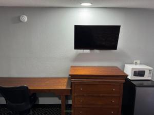a desk with a microwave and a tv on a wall at Budgetel Inn & Suites in Columbus