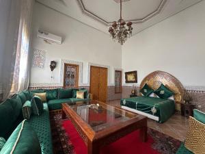 a living room with a green couch and a table at Riad Damia Suite & Spa in Fez