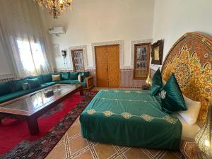 a living room with a green couch and a table at Riad Damia Suite & Spa in Fez