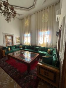 a living room with a green couch and a coffee table at Riad Damia Suite & Spa in Fez +201 photos