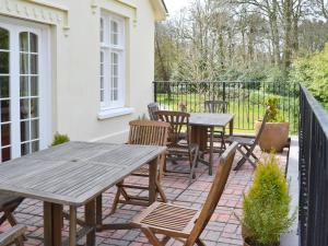 un patio con mesas de madera y sillas en el balcón en Luppincott Chambers - Hpps, en Bideford 8 fotos más