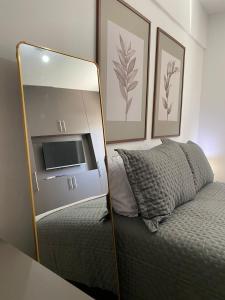 um espelho sentado ao lado de uma cama num quarto em Costa Nova VIP - Flat moderno e aconchegante em Ponta Verde em Maceió mais 50 fotografias