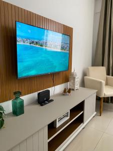 a living room with a flat screen tv on a wall at Flat Costa Nova VIP - em Ponta Verde - Apartamento 202 - 1 Quarto - Proximo a Praia in Maceió