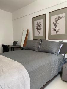 sypialnia z łóżkiem i biurkiem z laptopem w obiekcie Flat Costa Nova - Ponta Verde Maceió w mieście Maceió