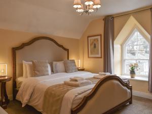 a bedroom with a large bed with towels on it at West View Apartment in Bowness-on-Windermere