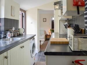 a kitchen with a sink and a washing machine at Molly's Place in Filey