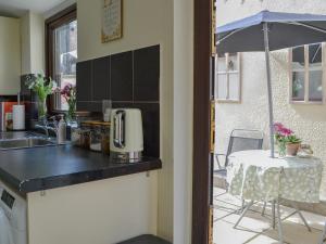 a kitchen with a counter and a table with an umbrella at Molly's Place in Filey +7 photos