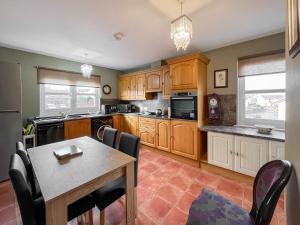 a kitchen with wooden cabinets and a table with chairs at Norwood in Thornhill