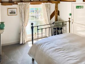 a bedroom with a bed and a window at The Knights Apartment, Eastbridge Hospital in Canterbury