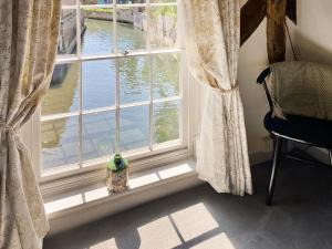 a window in a room with a view of the water at The Knights Apartment, Eastbridge Hospital in Canterbury