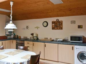 a kitchen with a table and a microwave and a table and a table at Dye Mill Cottage in Moffat