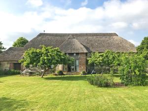 an old stone house with a grass roof at North Barn in Tolpuddle
