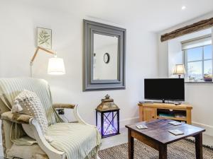 een woonkamer met een stoel en een tv bij Dukes Cottage - Uk47495 in Waterfall