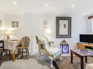 een woonkamer met een tafel en stoelen bij Dukes Cottage - Uk47495 in Waterfall