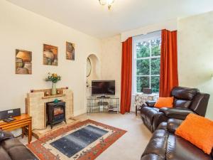 a living room with leather furniture and a fireplace at Isla Bank Cottage in Keith