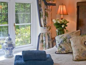 a room with a table with a pillow and a window at Grooms Cottage in Westleigh