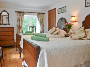 a bedroom with two beds and a dresser at Grooms Cottage in Westleigh +11 photos