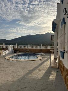 une piscine sur le côté d'un immeuble dans l'établissement CASA RURAL MALAGA,VILLA FAMARA,10 personas,DESAYUNO ANDALUZ INCLUIDO EN EL PRECIO, à Malaga