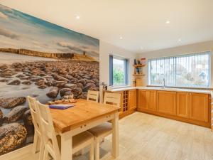 a dining room with a painting on the wall at Gan Hyem in Beadnell