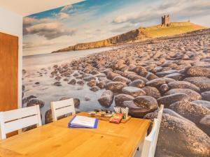 a dining room with a painting of a beach at Gan Hyem in Beadnell