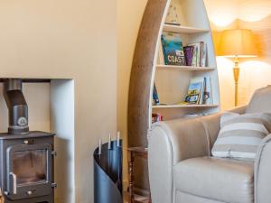 a living room with a couch and a wood stove at Gan Hyem in Beadnell +28 photos