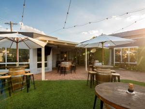 an outdoor patio with tables and chairs and umbrellas at ibis Styles Orange in Orange
