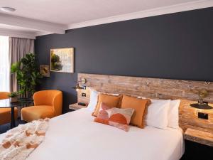 a bedroom with a large bed and a chair at ibis Styles Orange in Orange
