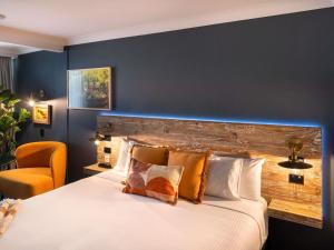 a bedroom with a large bed and a blue wall at ibis Styles Orange in Orange +35 photos