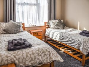 Un dormitorio con dos camas y una ventana. en Sarah's Seaside Bliss, en Cromer