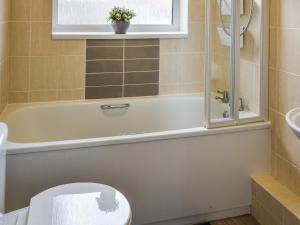 Un baño con bañera, inodoro y lavabo. en Sarah's Seaside Bliss, en Cromer 3 fotos más