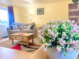 a living room with a couch and a pot of flowers at The Old Cook House in Winchester