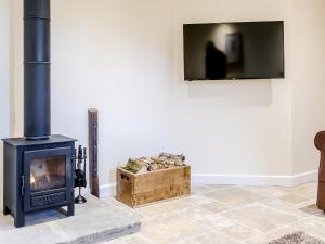 a living room with a wood stove and a box at Owl Barn -- Uk30757 in Bream