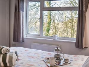 a bedroom with a bed and a window at Low Tide in Looe +2 photos