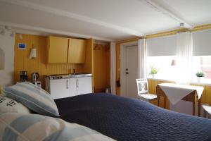 a bedroom with a large bed and a kitchen at Rum för två - centralt i Borgholm in Borgholm
