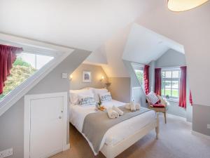 ein Schlafzimmer mit einem weißen Bett auf einem Dachboden in der Unterkunft Millhouse Cottage in Bamburgh