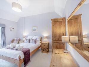 ein Schlafzimmer mit einem Bett und einem Tisch und zwei Lampen in der Unterkunft Millhouse Cottage in Bamburgh + 11 Fotos