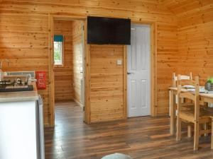 a kitchen with wooden walls and a dining room with a table at Wellington - Uk47055 in Holme upon Spalding Moor