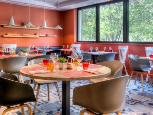 a dining room with tables and chairs and windows at Novotel Marseille Centre Prado Vélodrome in Marseille