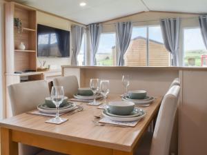 a dining room with a wooden table and chairs at Regal Lodge in Plumbland