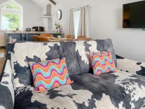 a couch with two colorful pillows on it in a living room at Bracken Cottage in Alston