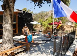 a patio with a flag and chairs and a tree at Sequoia Village in Three Rivers