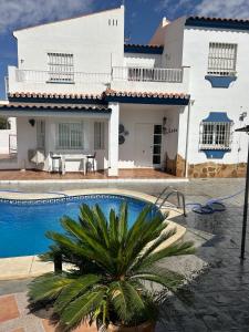 a villa with a swimming pool in front of a house at CASA RURAL MALAGA,VILLA FAMARA,10 personas,DESAYUNO ANDALUZ INCLUIDO EN EL PRECIO in Málaga