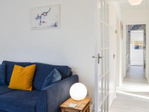a blue couch in a living room with a table at Driftwood Cottage in Sewerby